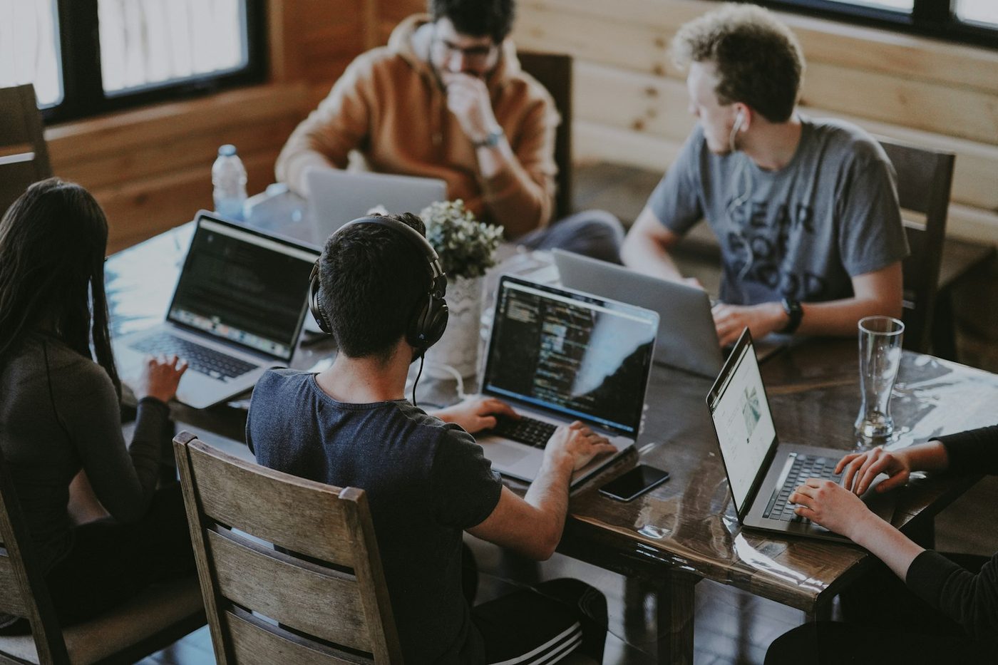 Professionals collaborating around a laptop during a team meeting in a bright office